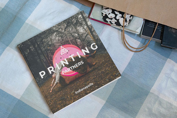 Square hardcover book titled 'Printing Partners' with a design featuring a pink circle and text on a patterned surface.