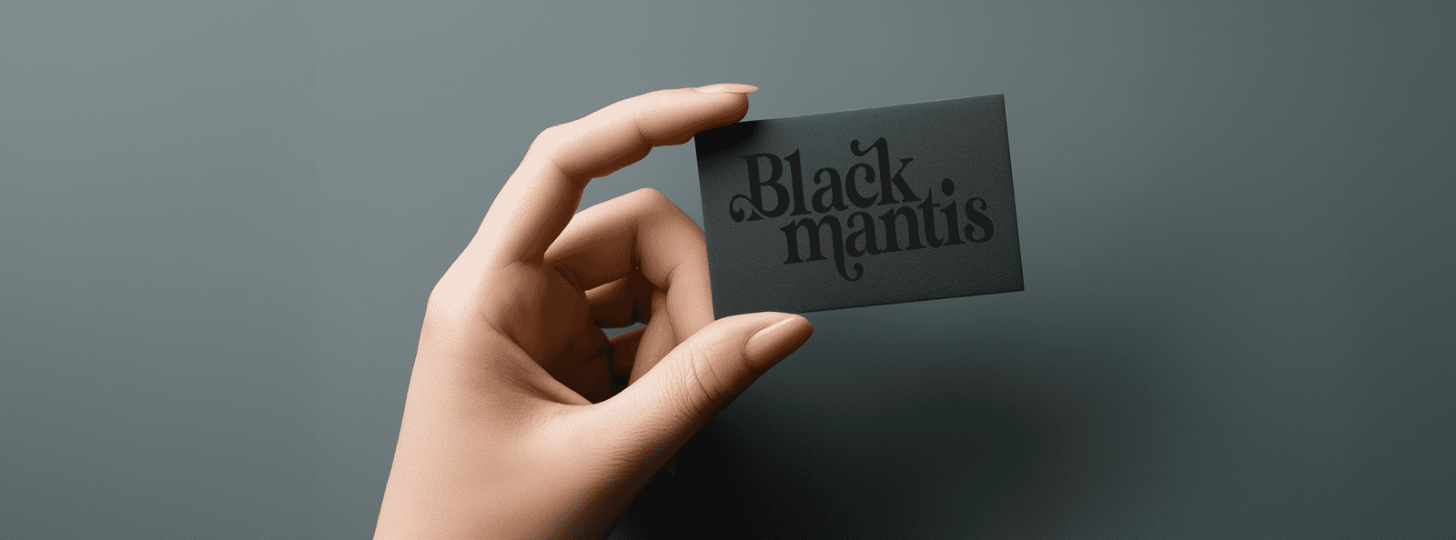 A hand holding a black business card with the text 'Black mantis' in a stylized font.