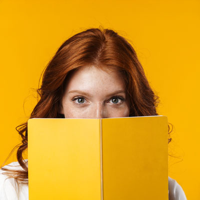 Image of ginger beautiful girl looking out for exercise book