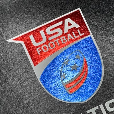 USA Football logo with red and blue metallic foil accents on a dark background.