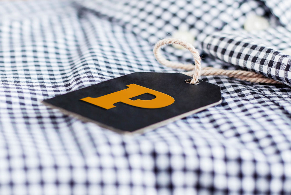 Thick black label with a letter 'P' attached to a checkered shirt.