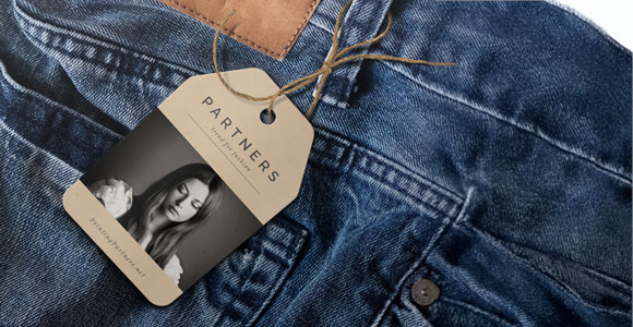 Hang tag attached to a pair of denim clothing featuring the word 'PARTNERS' and a model's image.
