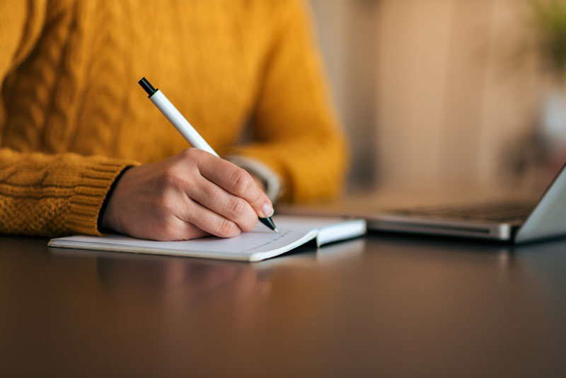 Close-up image of a girl making notes