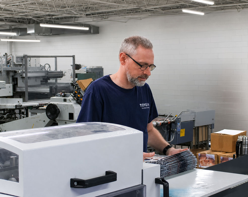 Printing Partners bindery technician finishing printed materials on the production floor