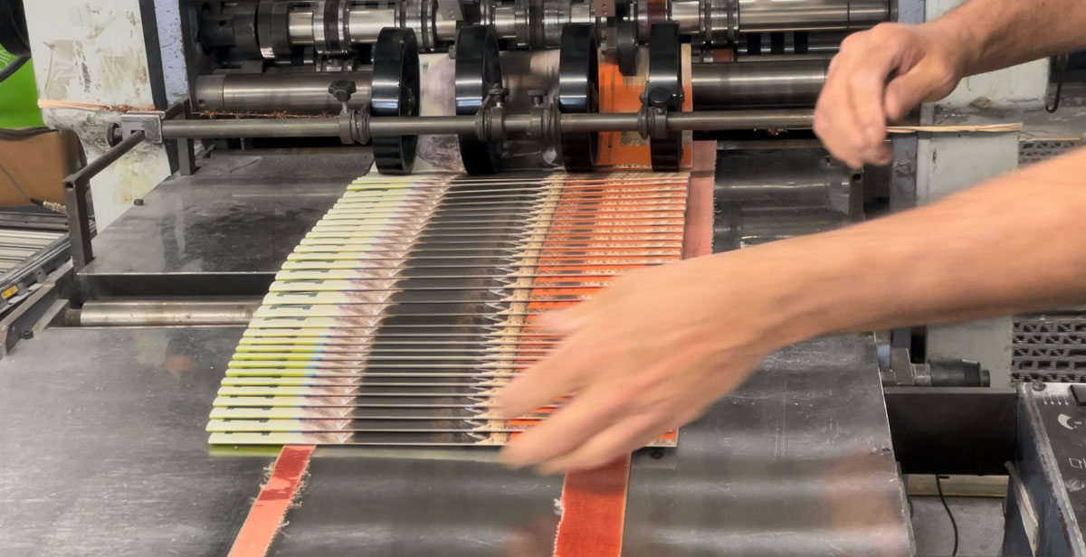Folded brochures being collected off the delivery of a folding machine on the Printing Partners bindery floor.
