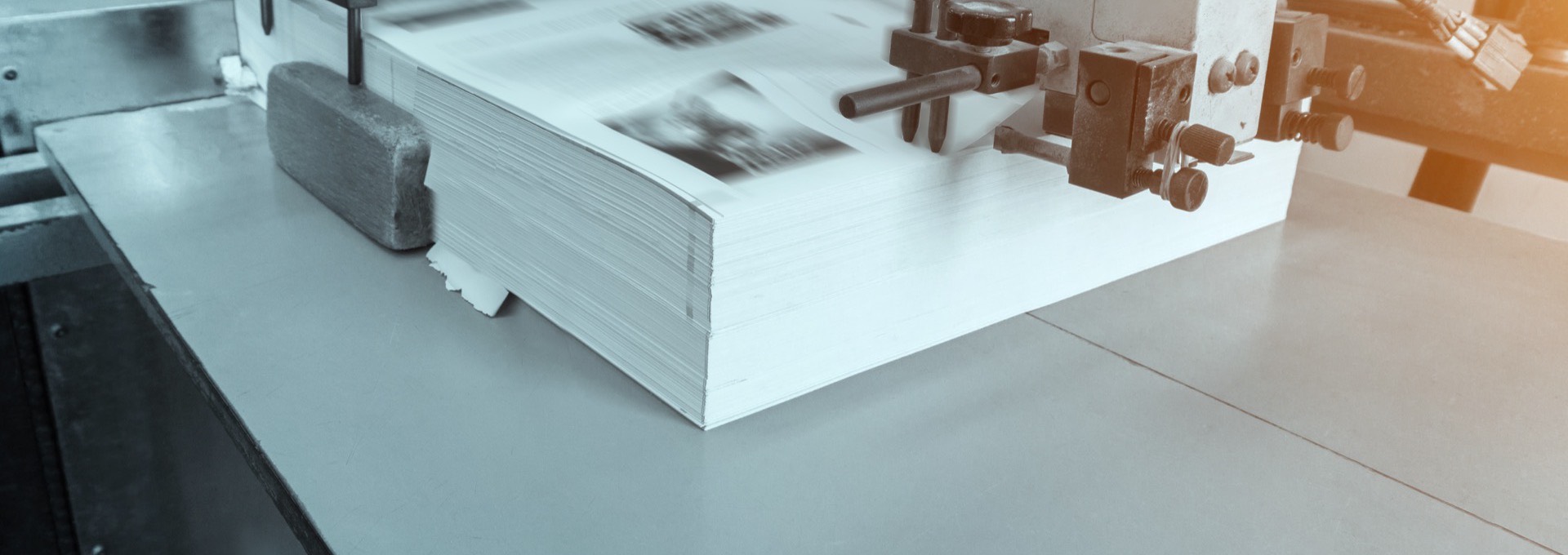Stack of printed sheets on an offset press in a commercial print shop