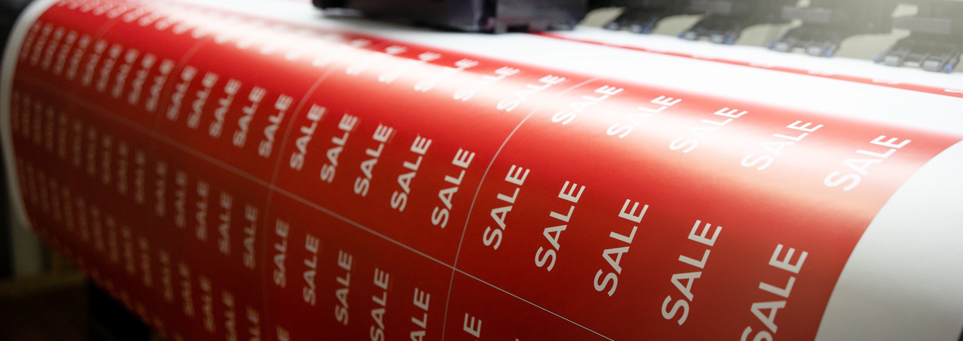 Printed vinyl banner material running through a large format press