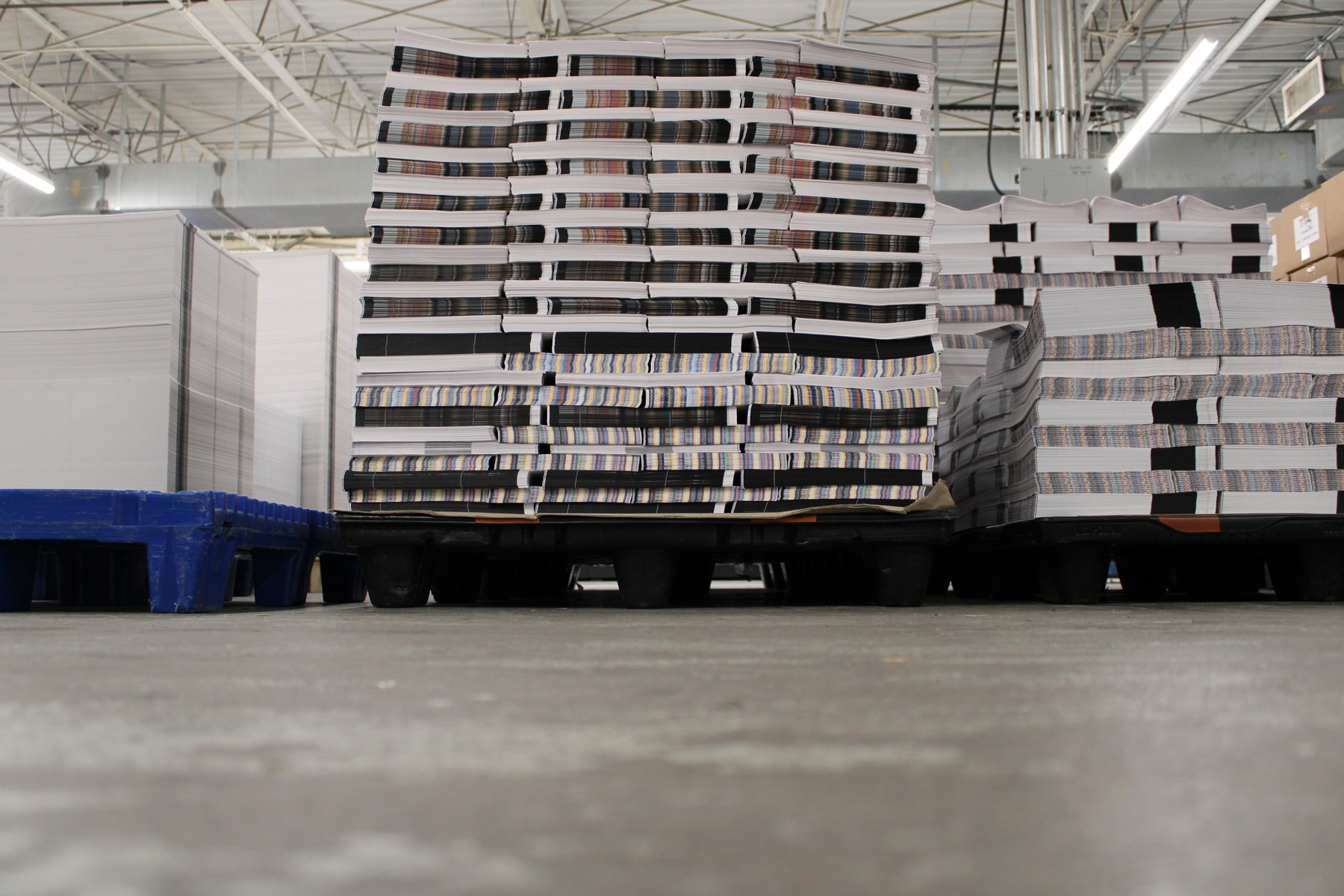 Pallets stacked with printed signatures on the Printing Partners production floor